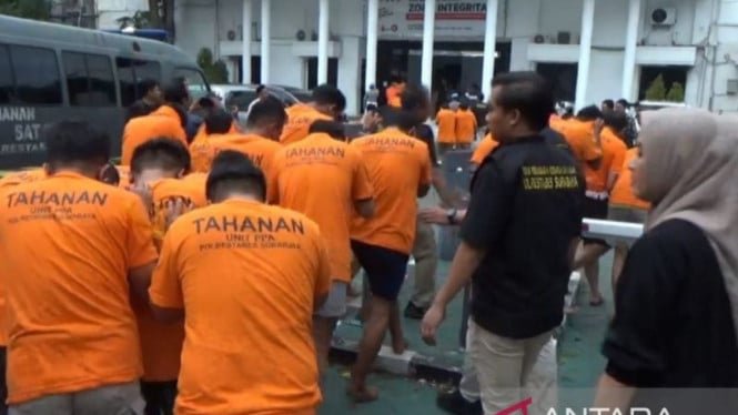68f8d32485408-polisi-menggiring-puluhan-tersangka-pesta-seks-gay-di-surabaya-ke-ruang-tahanan_665_374.jpg
