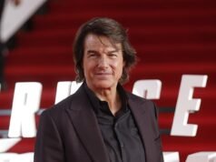 Los compañeros cienciólogos de Tom Cruise atacaron a los manifestantes con música de gaita cuando la estrella llegó en helicóptero a su sede en el Reino Unido.