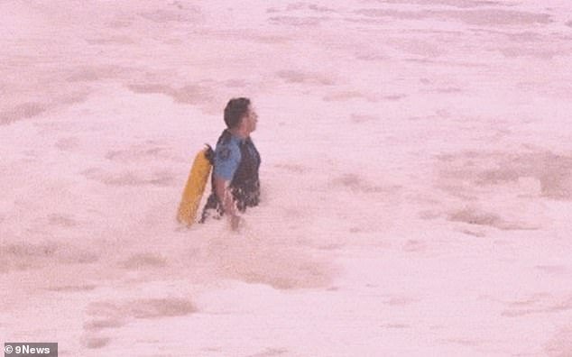 105144205-15425777-A_police_officer_is_seen_running_into_the_giant_swell_at_Coogee_-a-21_1767219878523.jpg