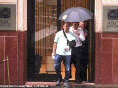 El héroe de la masacre de Bondi, Ahmed al-Ahmed, se ríe de camino al banco mientras invierte sus millones en ORO y es recibido por una estrella de rock en el centro financiero de Sydney.